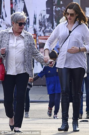 Bonding moment: During their stroll in downtown, the movie star placed her mom's hand on the center of her baby bump