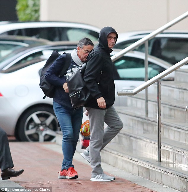 The casually-dressed United manager covered his head with a hood as he entered the building